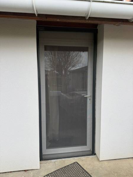 Pose de porte-fenêtre double vitrage à un seul ouvrant avec châssis PVC blanc avec moustiquaire plissée latérale haut de gamme à Colomiers